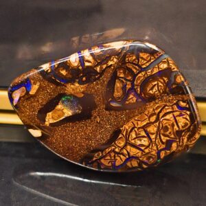The Mystical Natural Queensland Boulder Opal 32 Ct features polished low dome design, vibrant blue, green, orange, gold, purple colours, and natural ironstone matrix patterns.