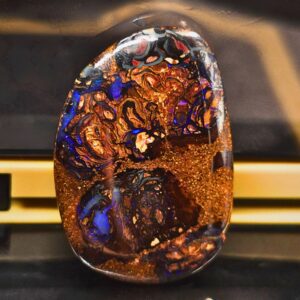 The Mesmerizing Natural Queensland Boulder Opal 21.3 Ct displaying blue and purple flashes, natural ironstone matrix, freeform low dome design from Australia.