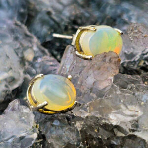 Isel Nuvé S925 sterling silver stud earrings featuring Lightning Ridge natural crystal opals with vivid green flashes, clean minimalist design, soft luminous glow.