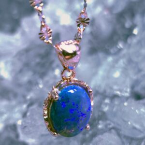 Rose gold-plated S925 necklace featuring 1.50ct Lightning Ridge natural Dark Crystal Opal, oval cut, medium dome, 40 cm chain link, glowing blue tones, feminine luxury jewelry piece.