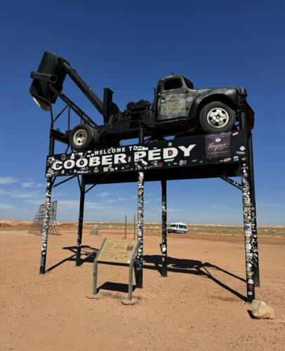 A vintage truck displayed atop a sign welcomes visitors to Coober Pedy, an iconic Australian opal mining town.