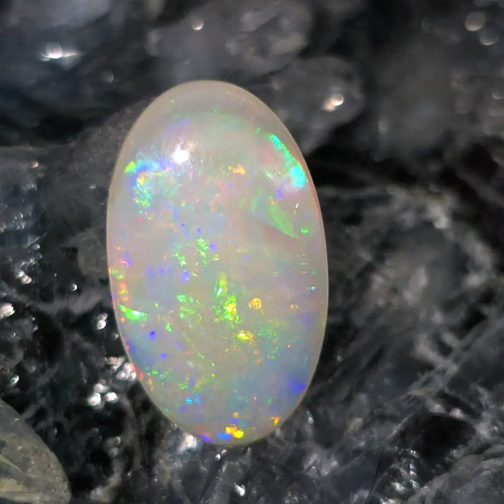 CPFOSPO-1798 (1) Lume Kai 4.60 ct solid, natural white opal shell fossil from Coober Pedy, polished oval with medium dome, displaying shifting flashes of blue, green, orange, gold, and pink, symbolizing protection, transformation, and radiant beauty.