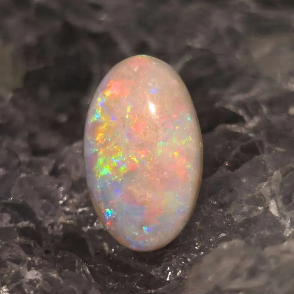 CPFOSPO-1799 (5) Luminous Selune Fosséa natural dark fossil shell opal from Coober Pedy, Australia, 4 ct, polished oval shape, medium dome, vibrant rainbow flashes of blue, green, gold, pink, red, and purple.